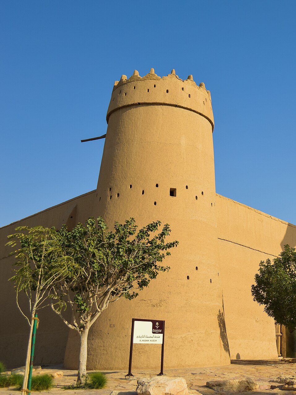 The round mud-brick corner tower of Masmak Fort in Riyadh against a clear sky
